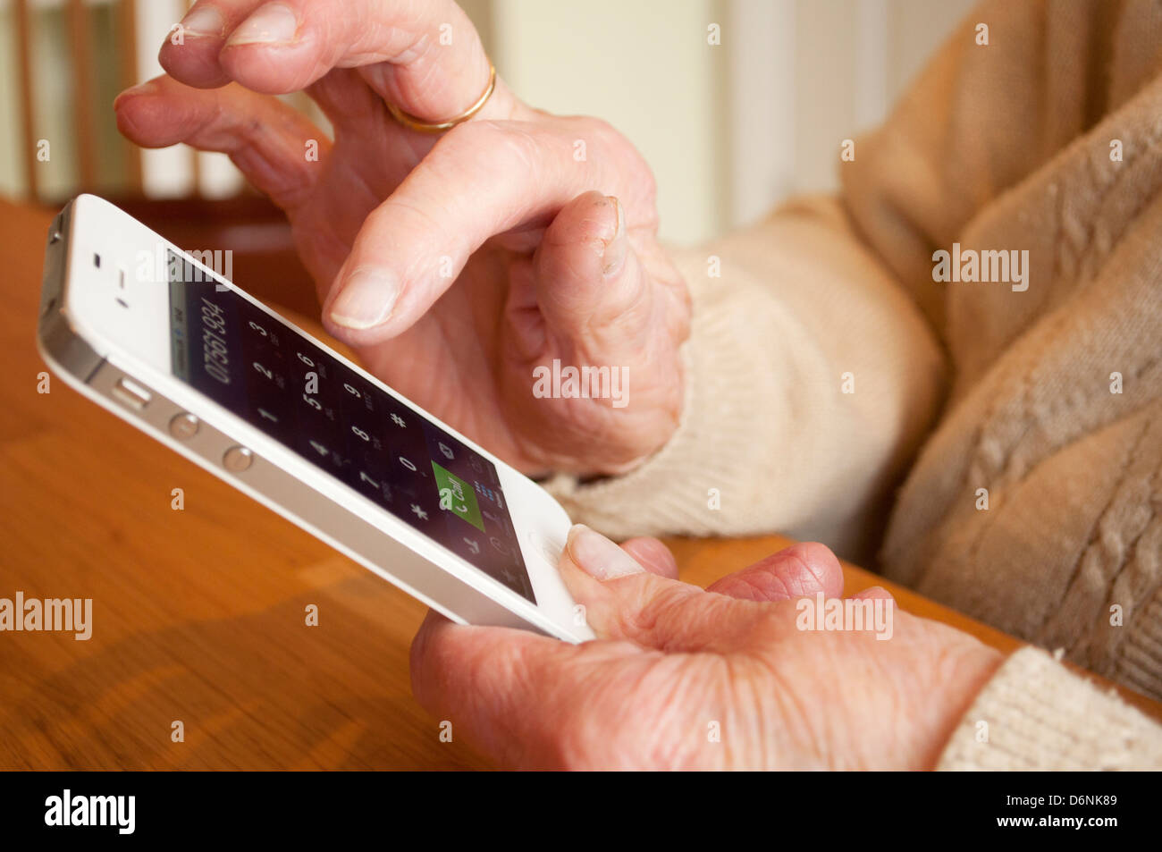 Les mains d'une femme âgée à l'aide d'iPhone Banque D'Images