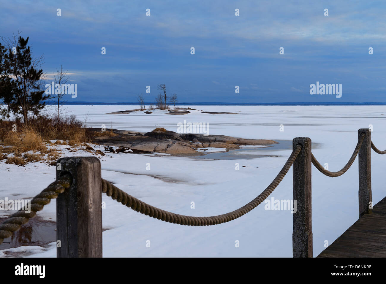 Main courante corde de quai sur le lac Nipissing après une tempête de neige de printemps, à North Bay, Ontario Canada au coucher du soleil Banque D'Images