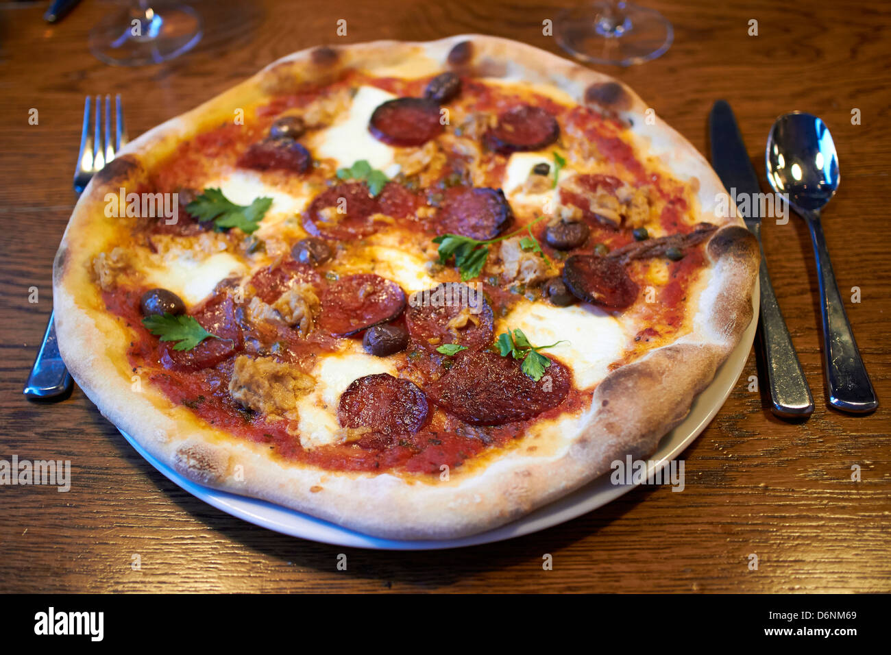 Pizza au Pepperoni pepperoni garni de saucisse et de l'anchois servi dans un restaurant. Banque D'Images