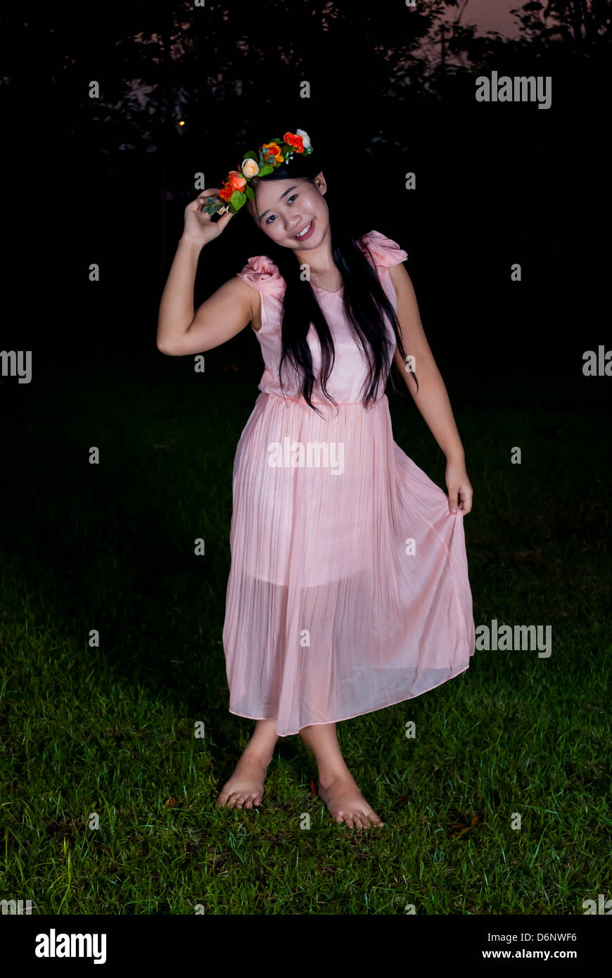 Thai girl asiatique est tenue dans le parc de la couronne de fleurs Banque D'Images