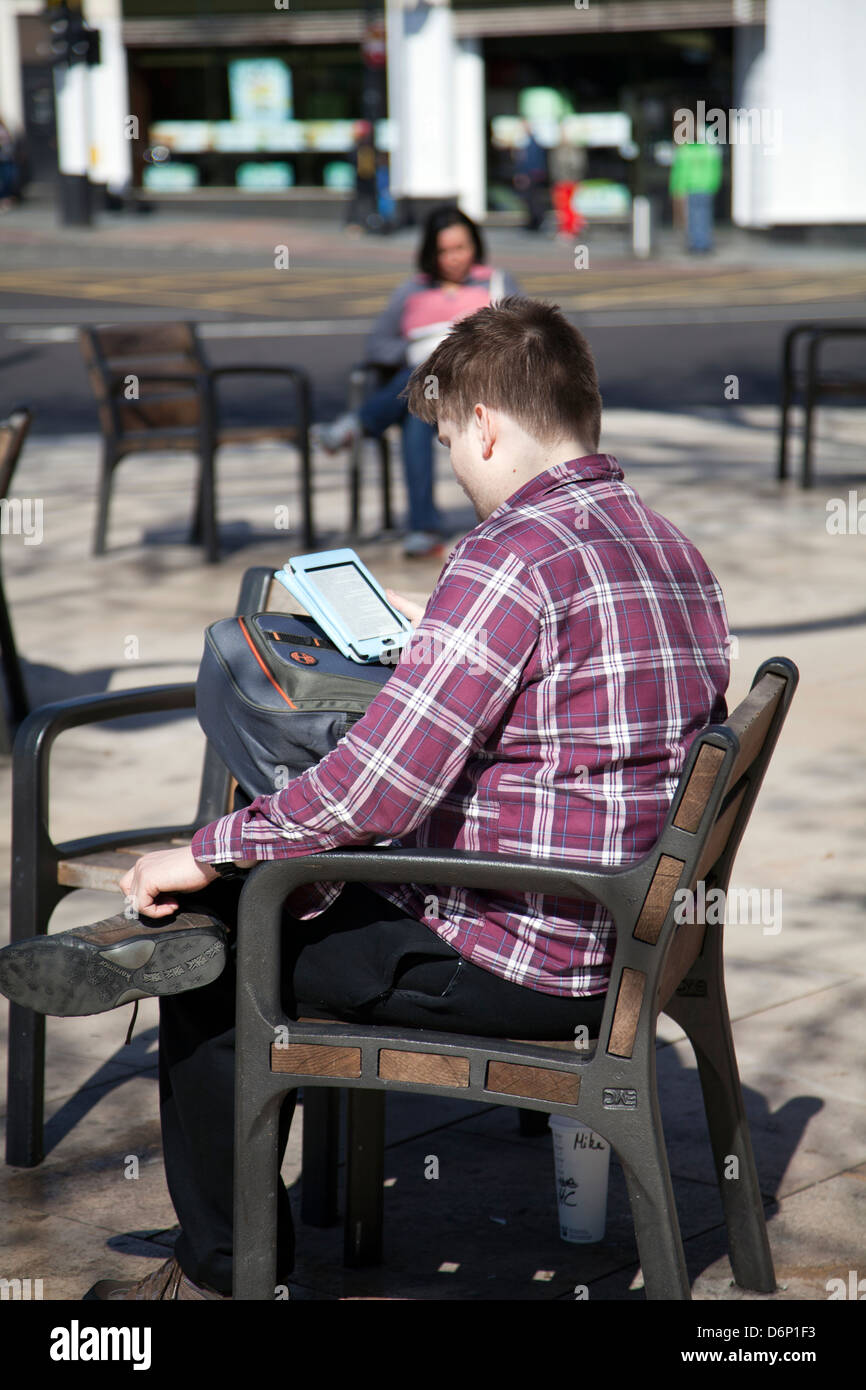 Brixton Windrush Square - Homme lecture périphérique Kindle dans Lambeth - London UK Banque D'Images