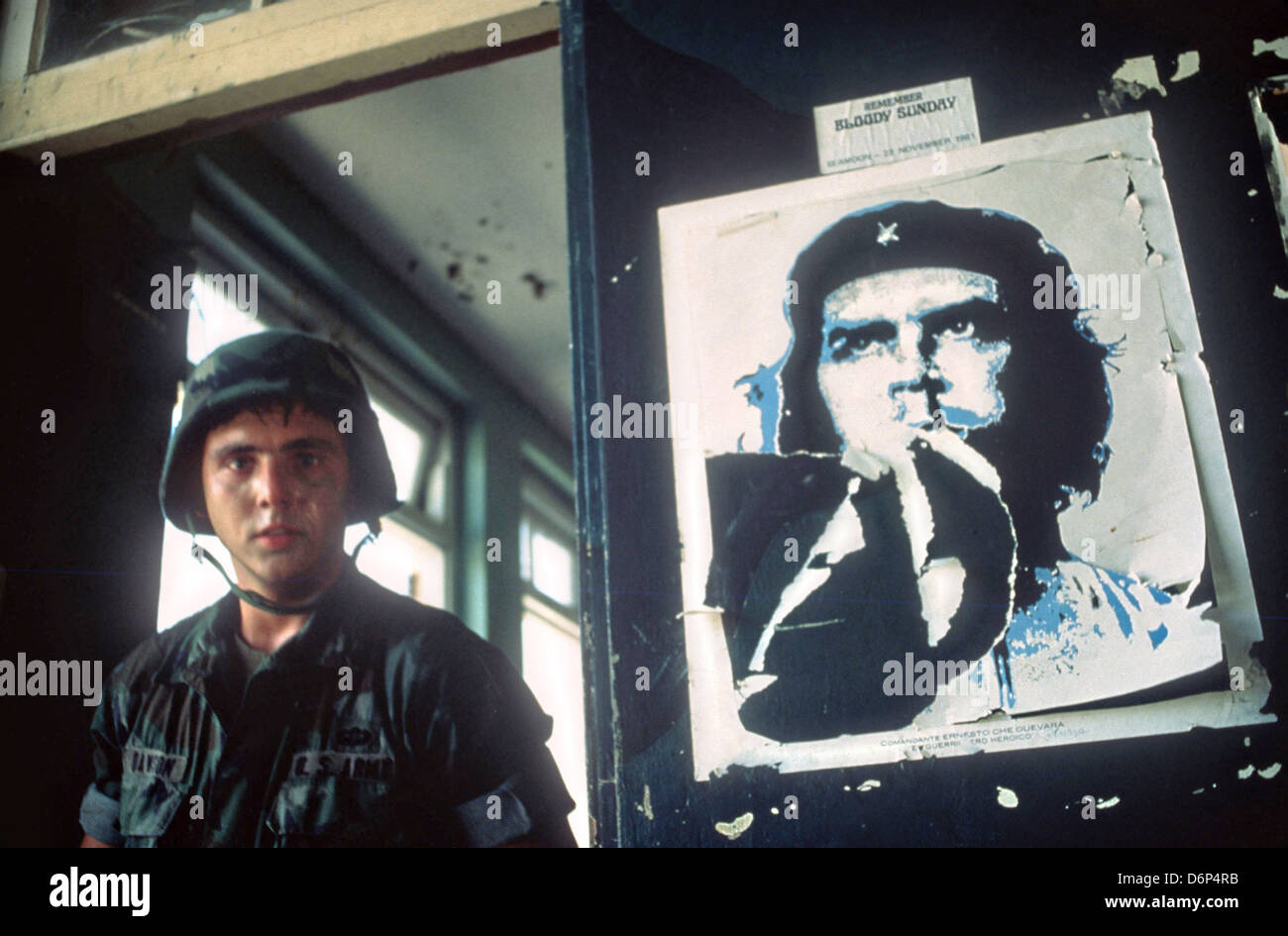 Un soldat 82nd Airborne Division est à côté d'un poster de Che Guevara, révolutionnaire cubain au dépôt d'approvisionnement frequente où une grande cache d'armes a été saisie lors de l'invasion de la Grenade, de code opération Urgent Fury Le 25 octobre 1983 à St Georges, Grenade. L'invasion a commencé le 3 novembre 1983 et a été la première grande intervention militaire des États-Unis depuis la fin de la guerre du Vietnam. Banque D'Images