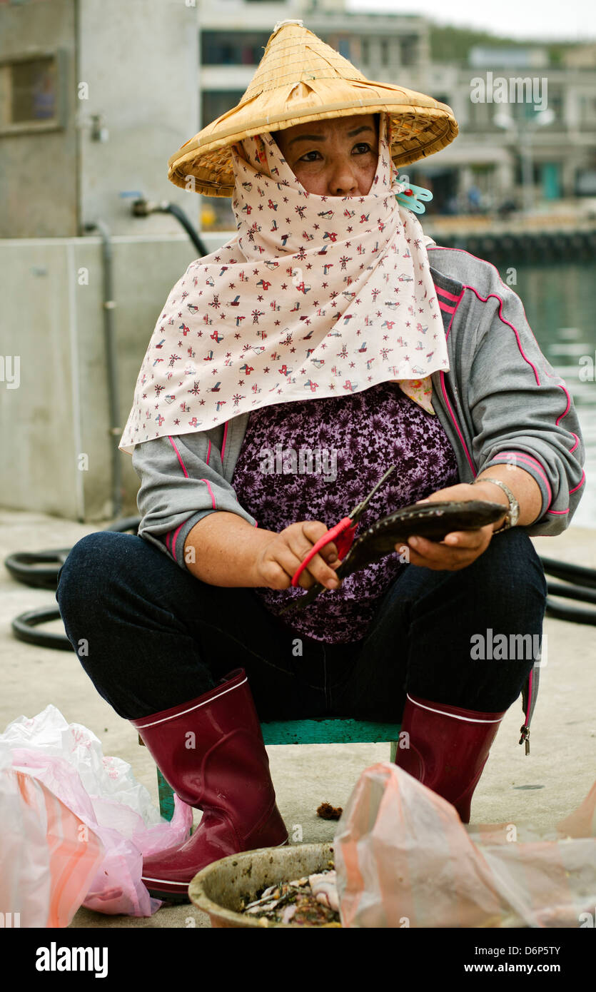 Femme vêtue d'un chapeau chinois le nettoyage du poisson, Taïwan, Penghu,  Chimei Photo Stock - Alamy