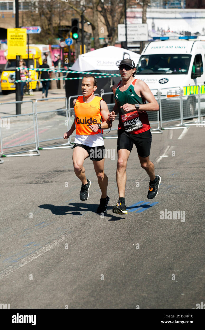Le Portugais Gabriel Macchi, accompagné de son coureur-guide, en compétition dans le Marathon de Londres 2013. Banque D'Images