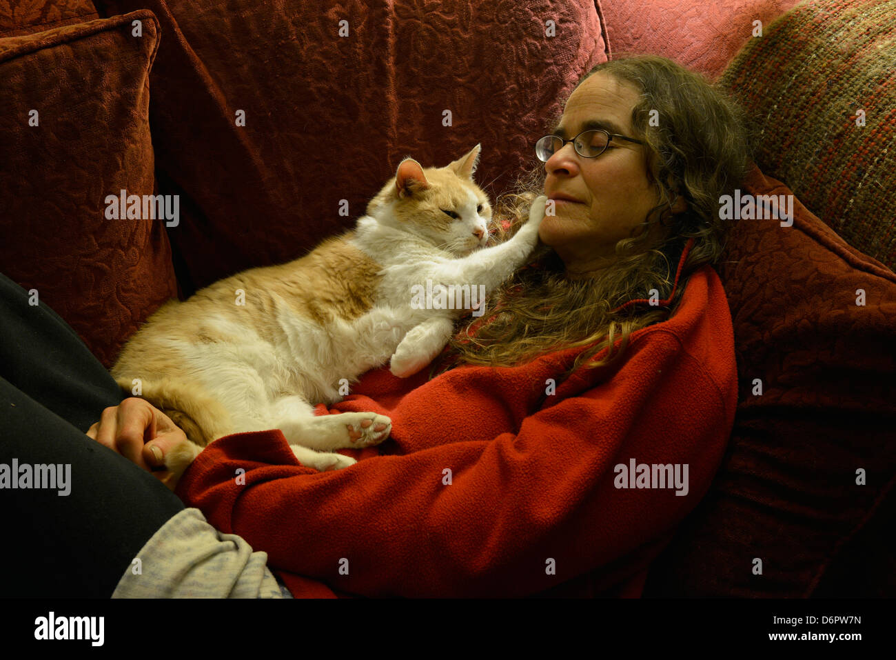 Femme et chat sieste sur canapé. Banque D'Images