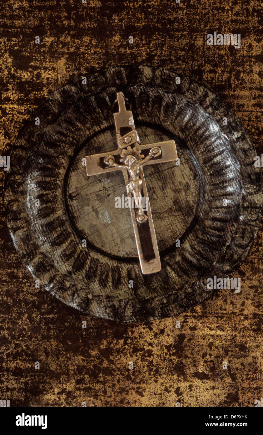 Close up argent noir crucifix Jésus Christ gisant sur le plat à motifs de fond d'étain d'argent terni terni rusty metal doré Banque D'Images