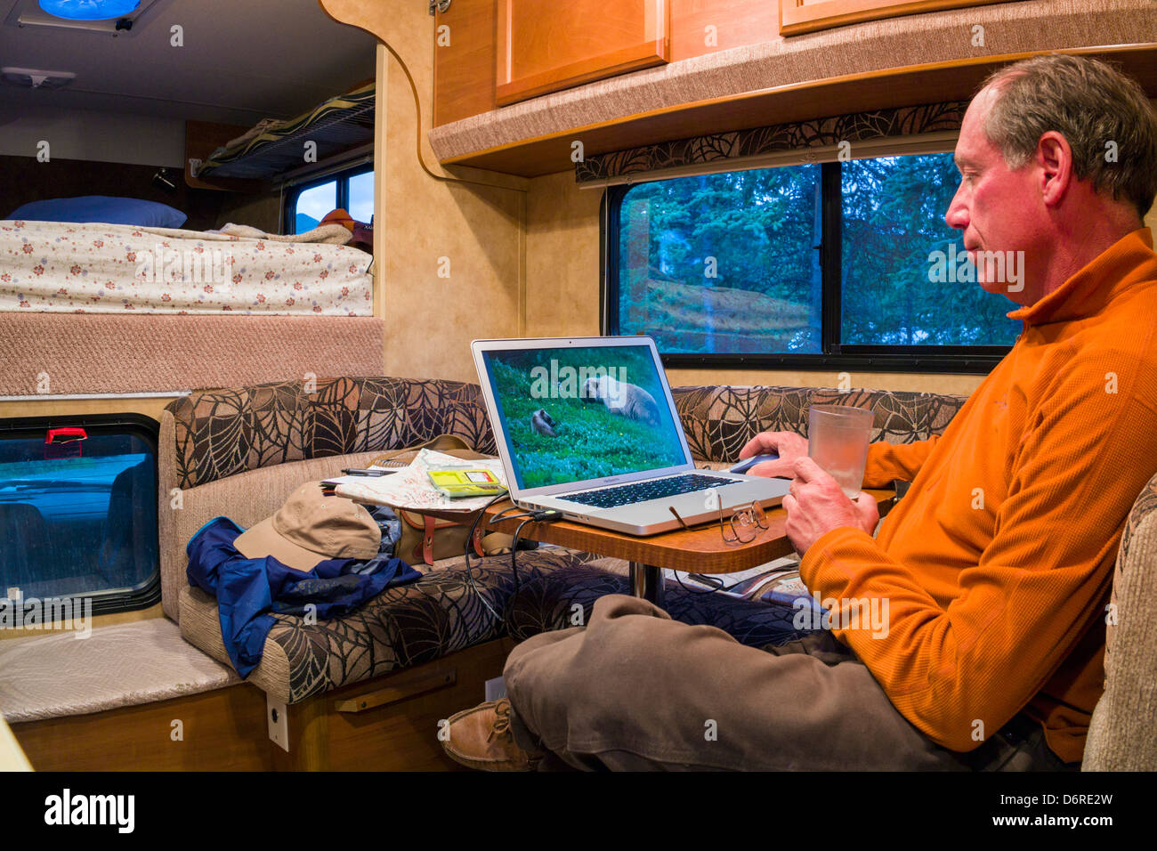 Photographe professionnel H. Mark Weidman modifier photos numériques sur un ordinateur portable à l'intérieur d'un camping-Denali National Park Banque D'Images
