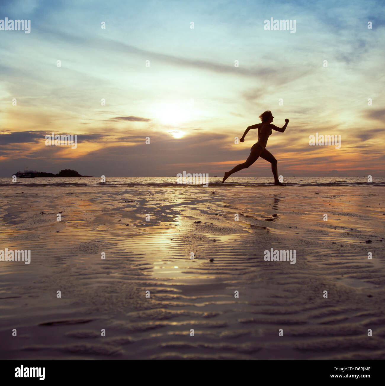 Objectif, silhouette de femme aux pieds nus s'exécutant sur la plage Banque D'Images
