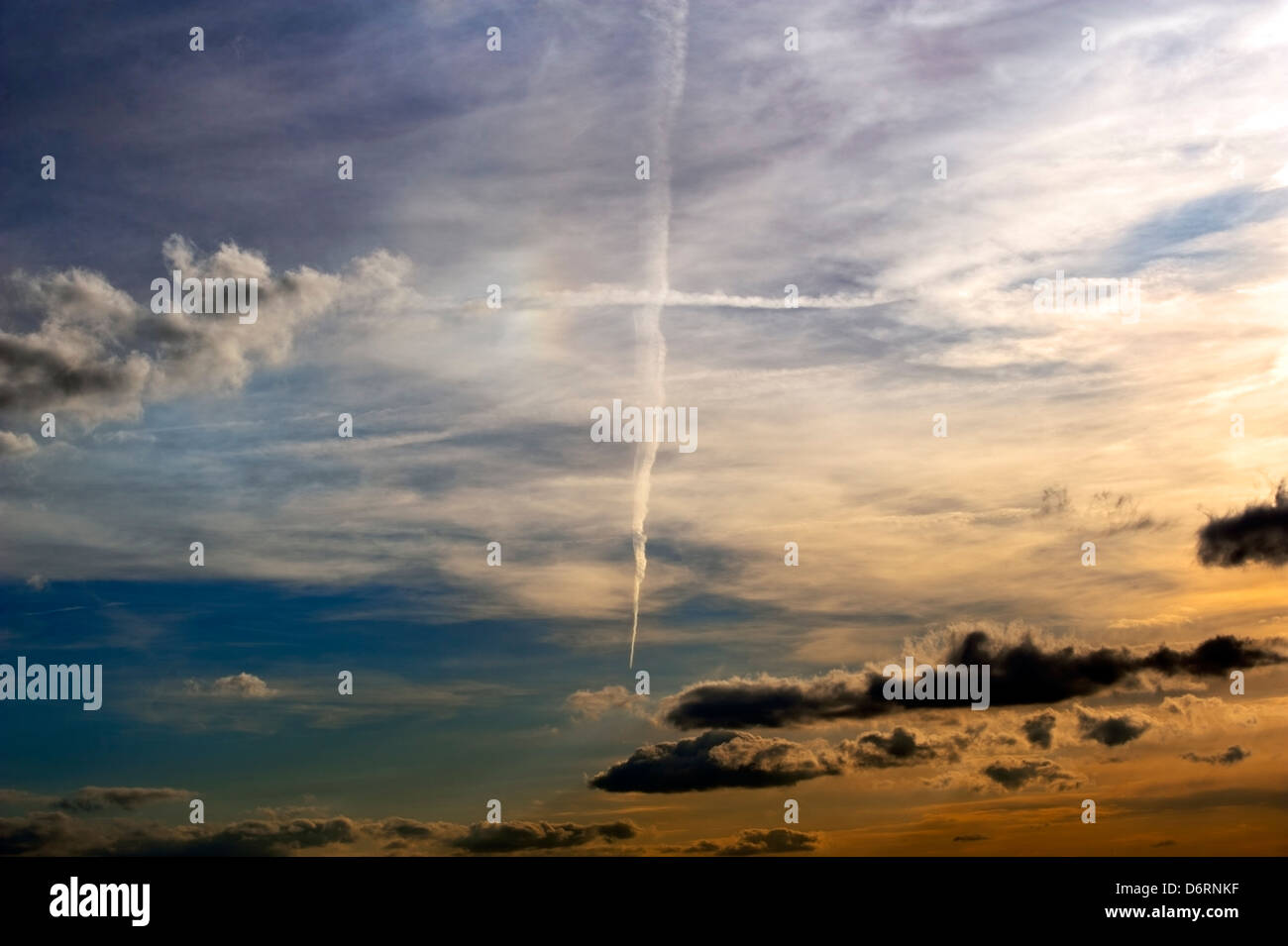 Trainées formant une croix dans un ciel dramatique Banque D'Images