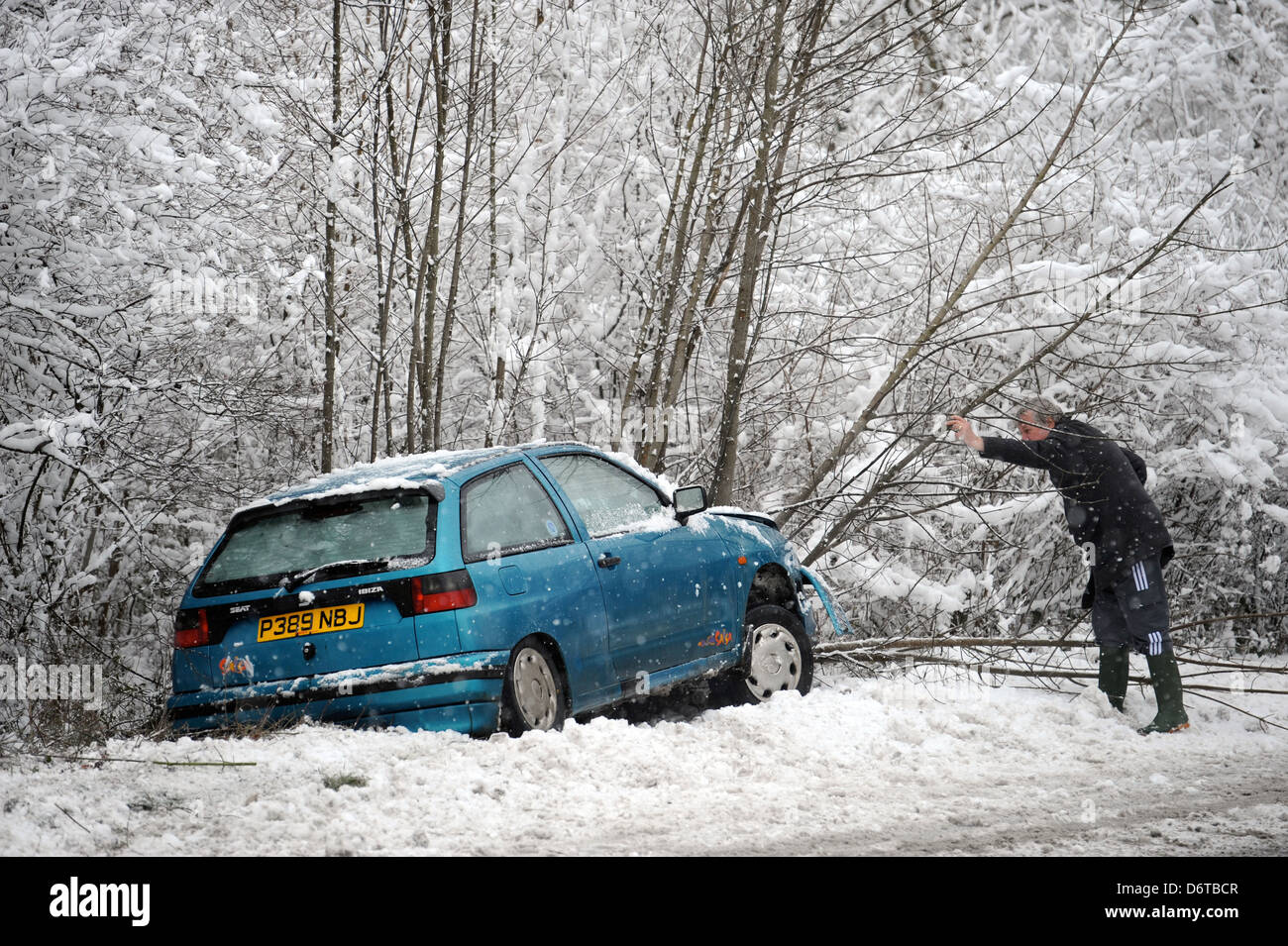 Une voiture qui a quitté la route dans la neige près de Stroud, Gloucestershire UK Banque D'Images