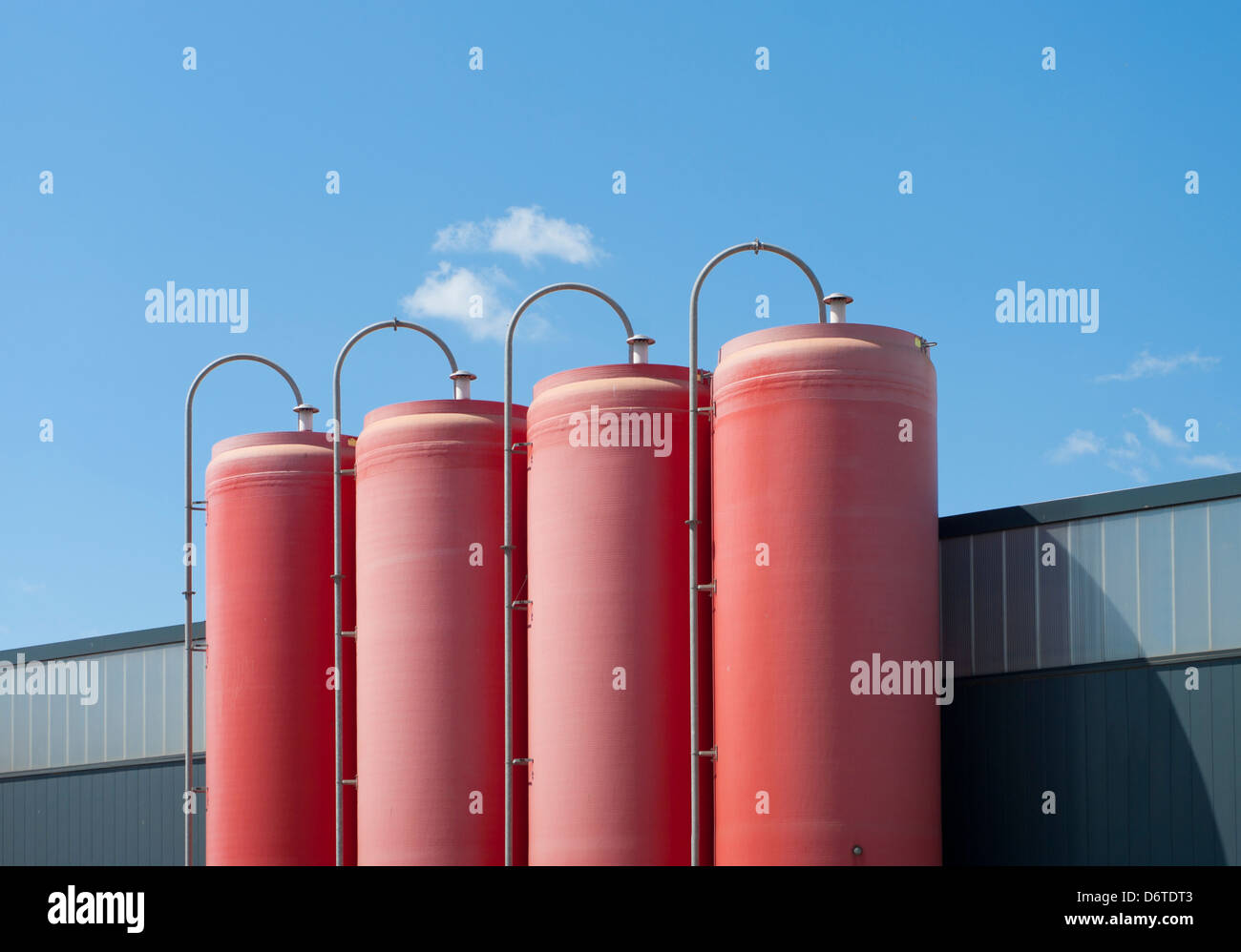 Quatre silos rouge industriel appartenant à une usine de ciment Banque D'Images