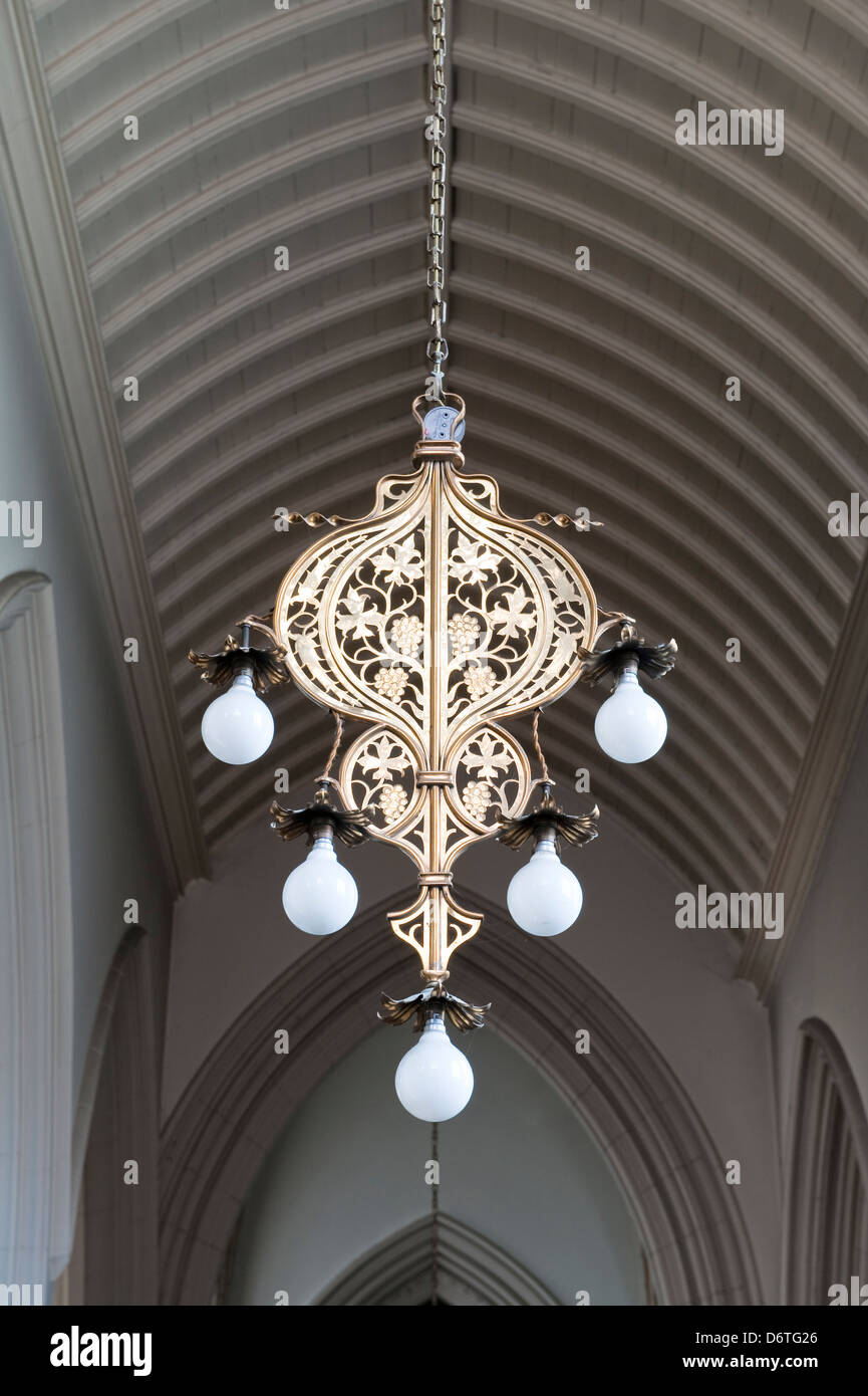Un éclairage électrique suspendu (electrolier) datant de la fin de l'époque victorienne, conçu par John Francis Bentley, dans l'église St Mary's Church, Clapham, Londres, Royaume-Uni Banque D'Images