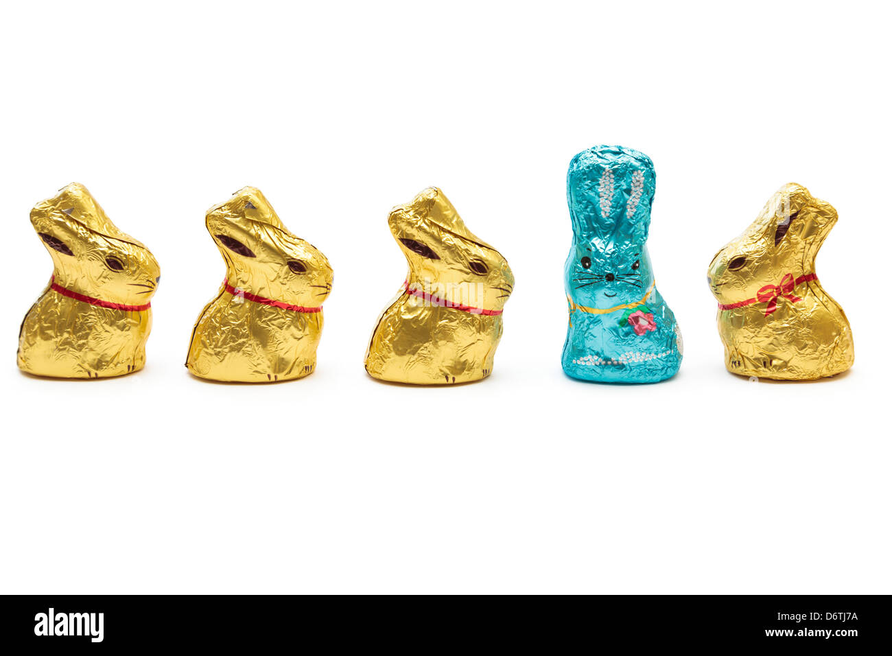 Chocolat or jaune quatre lapins de Pâques à la recherche d'un lapin de Pâques bleu pour illustrer de se démarquer de la foule et concept de leadership Banque D'Images