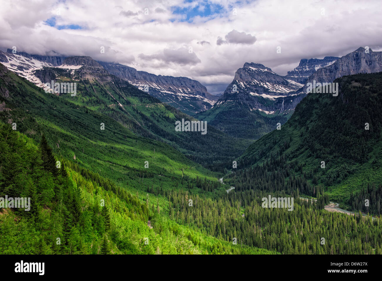 Photographie d'une tempête au cours de la dispersion d'une vallée alpine, avec la lumière du soleil brillait au-dessus de la forêt. Banque D'Images