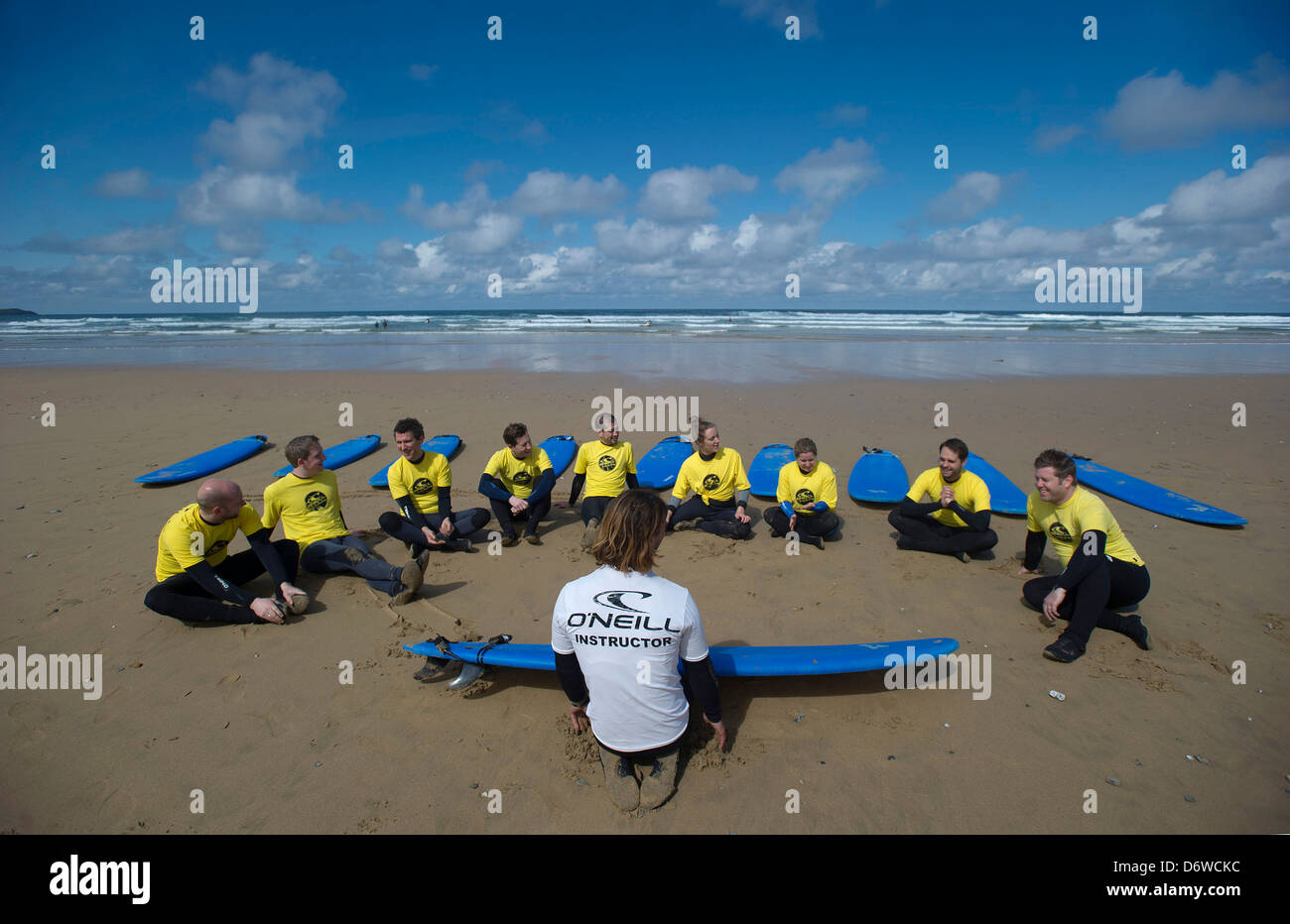 Les étudiants au cours d'une leçon de surf sur la plage à Watergate Bay, Cornwall, UK Banque D'Images