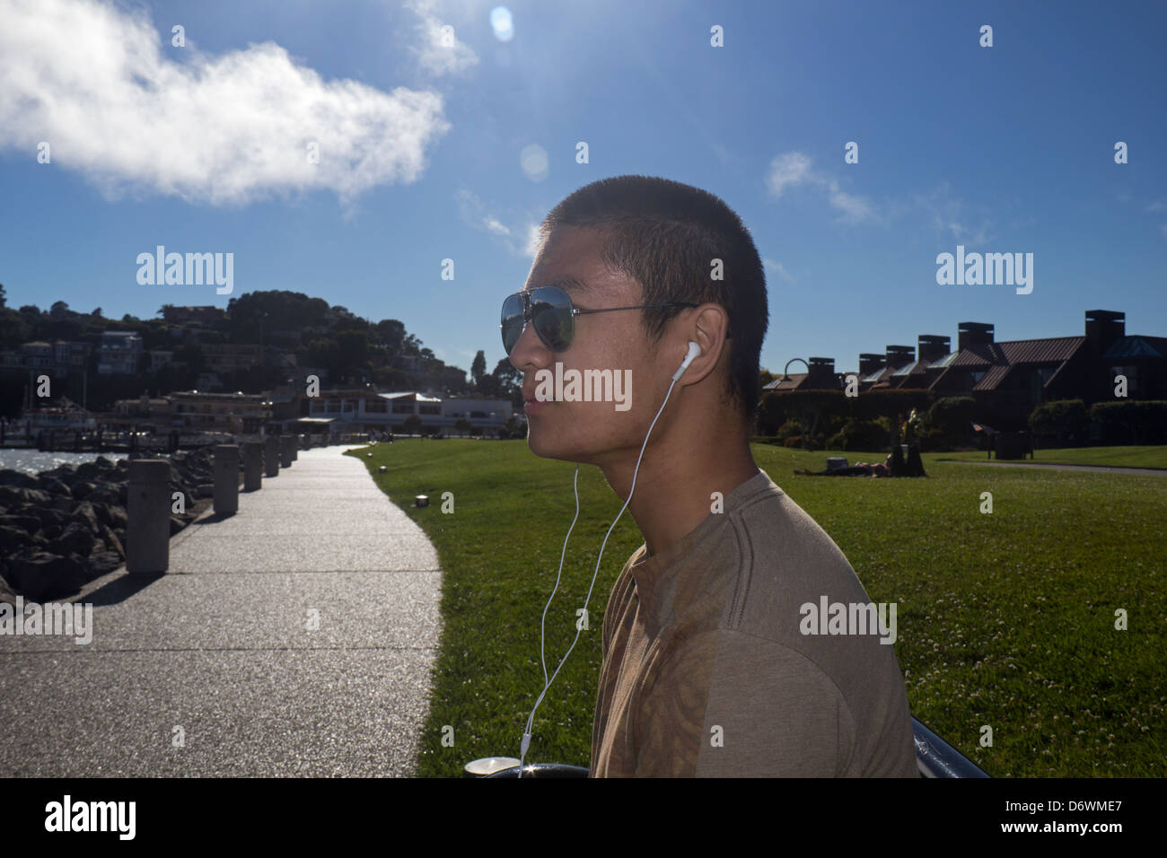 Jeune homme asiatique de l'écoute d'un ipod music, Tiburon, California, USA Banque D'Images