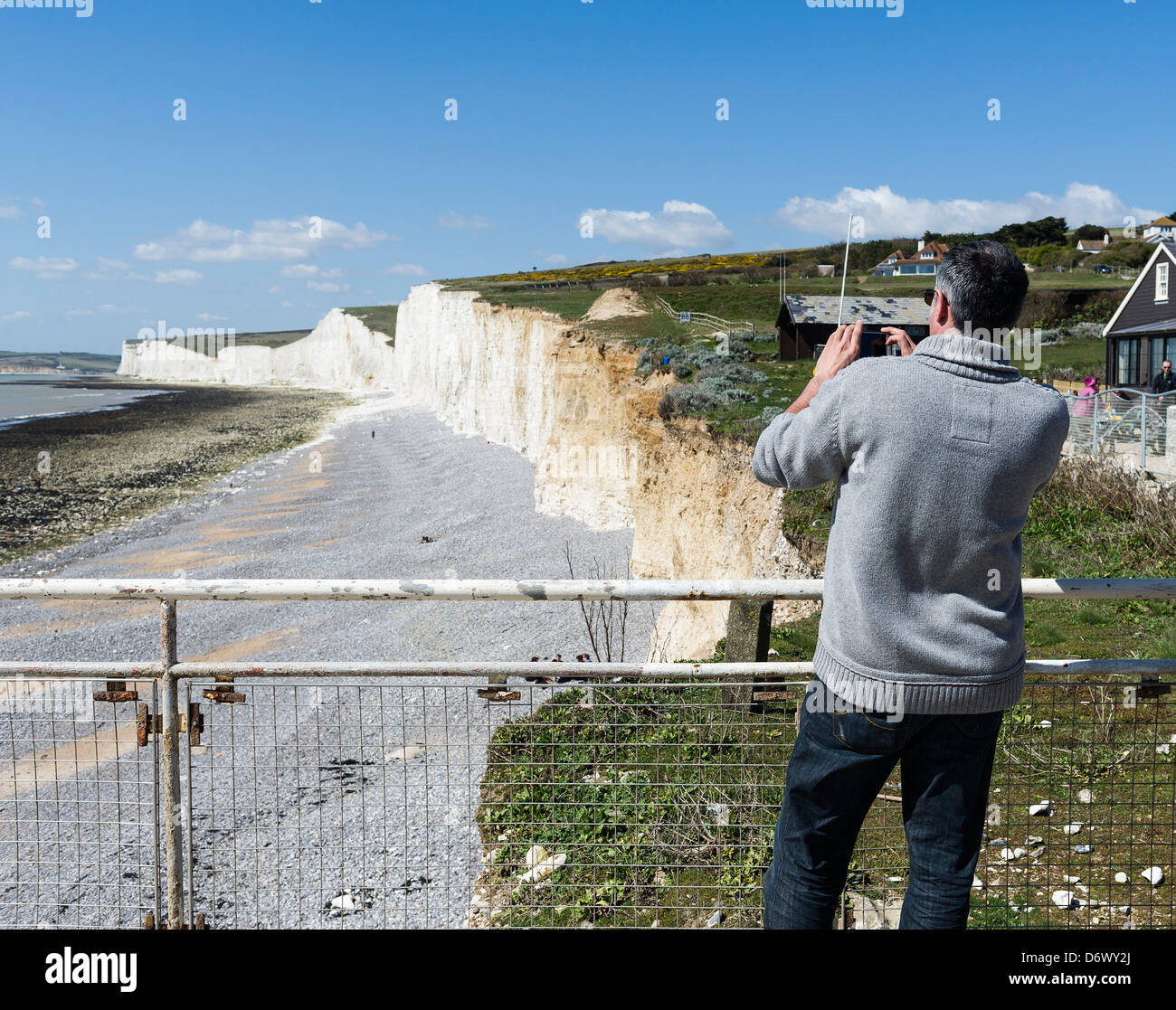 Un homme de prendre une photo de la plage à Urrugne dans l'East Sussex. Banque D'Images