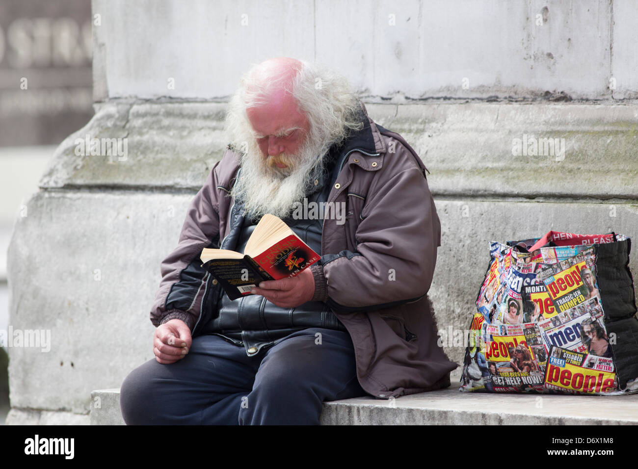 Un clochard la lecture d'un livre à Londres Photo Stock - Alamy