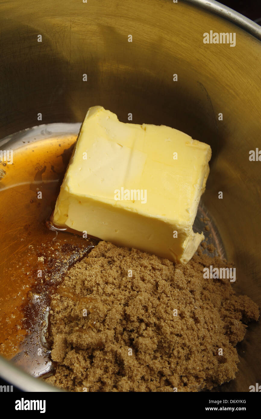 Le sucre muscovado, le beurre et le miel dans une casserole de fusion Banque D'Images