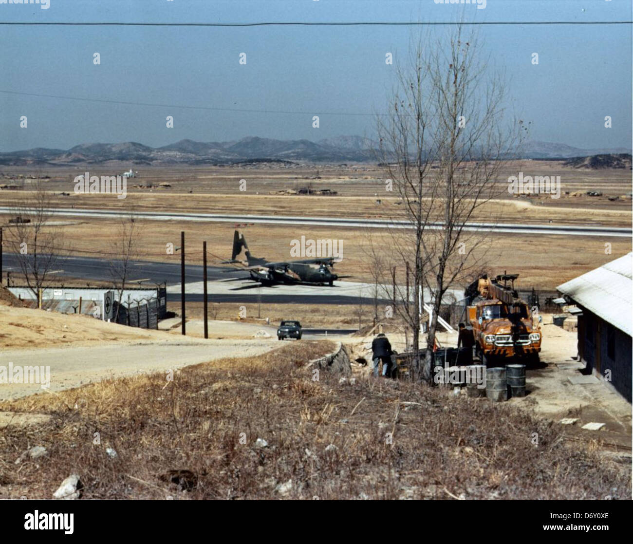 La photographie de GENE Timmons prise à Osan en mars 1970 montre un Lockheed C-130 Hercules et un DC-130 Hercules, soulignant leur rôle dans l'aviation militaire. Ces avions ont été utilisés pour le transport, la reconnaissance et le contrôle de drones pendant la guerre froide. Banque D'Images