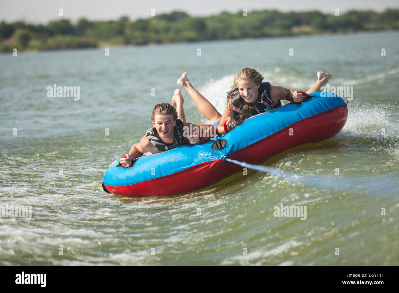 USA, Texas, Lewisville, deux adolescents équitation sur le tube intérieur dans le lac Lewisville Banque D'Images