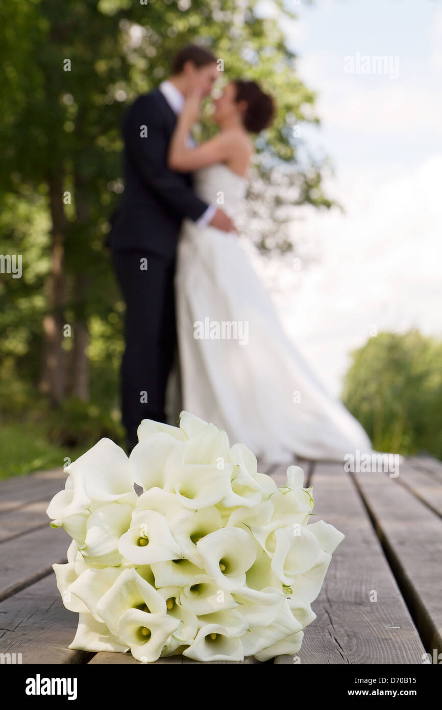 Bouguet de mariage dans l'accent en premier plan, senior couple kissing presque dehors de la vue en arrière-plan Banque D'Images Bouguet de mariage dans l'accent en premier plan, senior couple kissing presque dehors de la vue en arrière-plan Banque D'Images