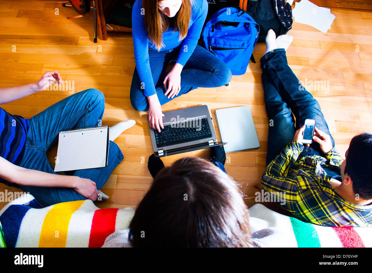 Vue aérienne d'un groupe d'adolescents sur le plancher sur un projet en utilisant différents moyens et techniques. multi media concept Banque D'Images