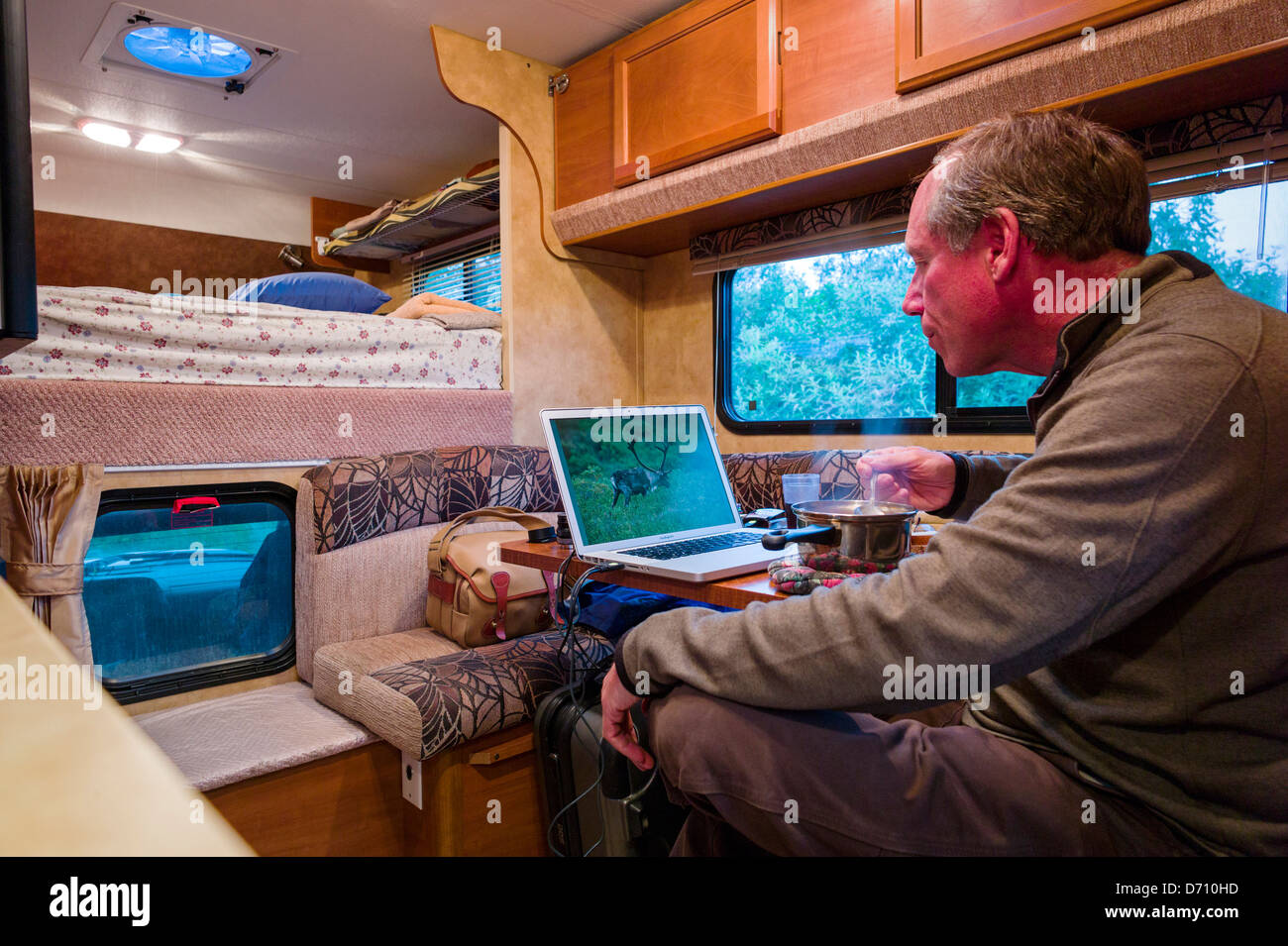 L'édition de photographe professionnel photos numériques sur un ordinateur portable à l'intérieur d'un camping-camion, Denali National Park, Alaska USA Banque D'Images