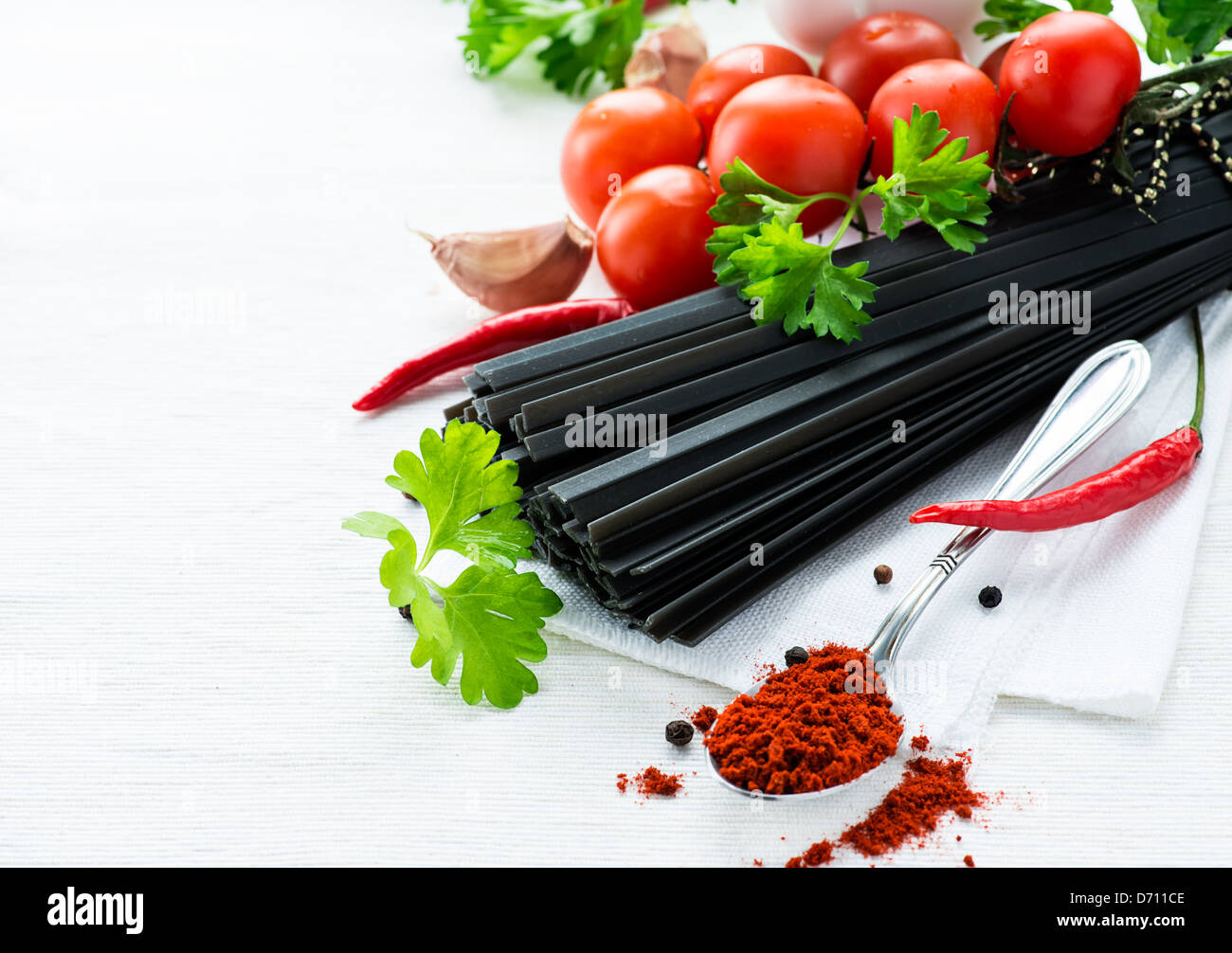 Les pâtes noires non cuites avec des tomates, fines herbes et épices, selective focus Banque D'Images