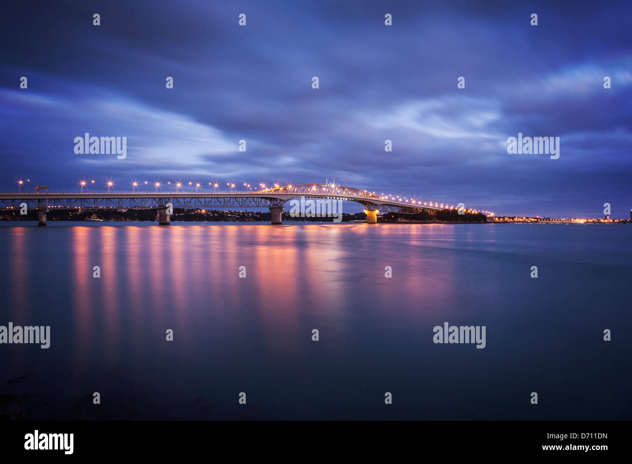 Auckland Harbour Bridge avec ses lumières sur au crépuscule. Banque D'Images