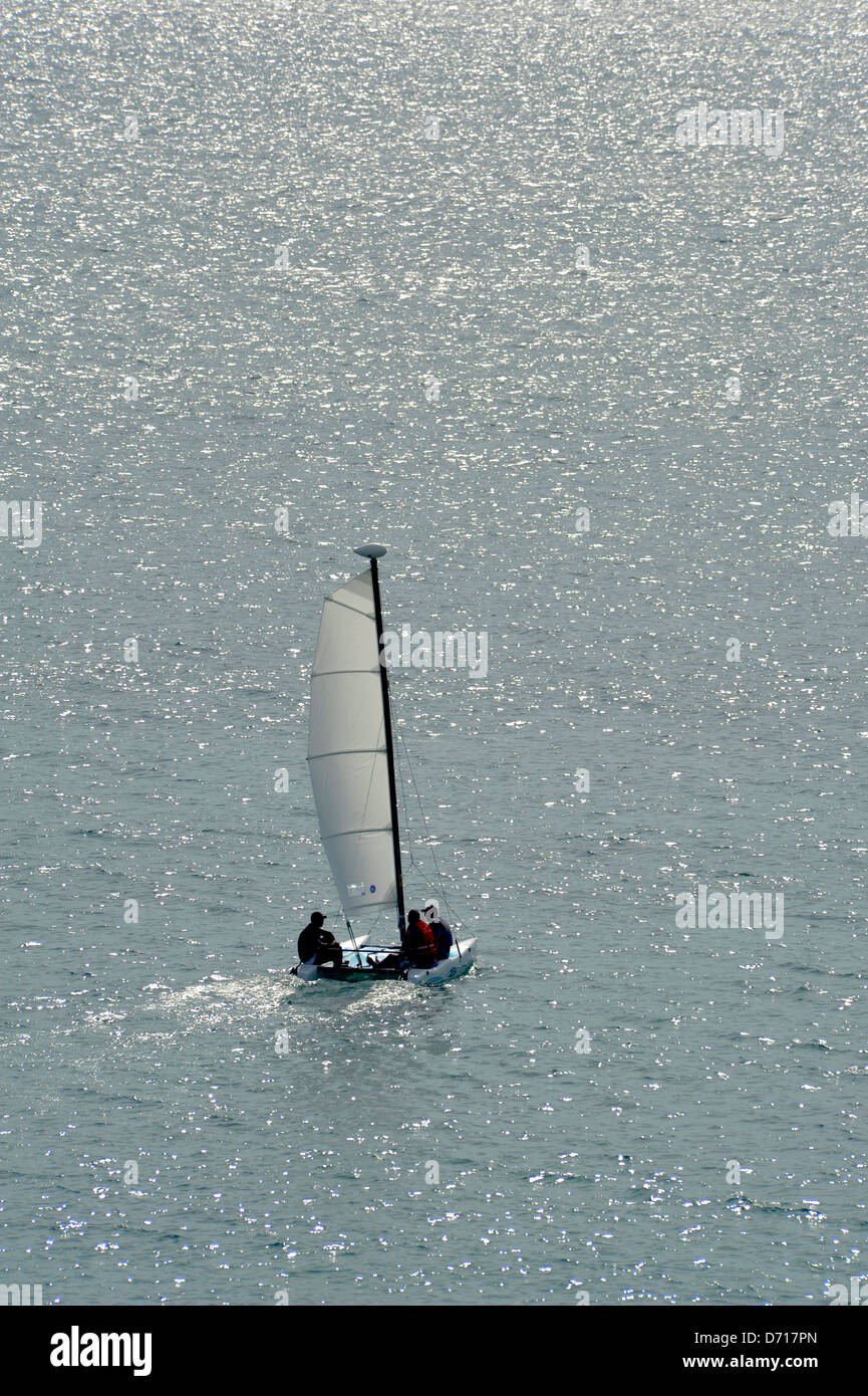 Petit voilier en direction de la mer de la rive Banque D'Images