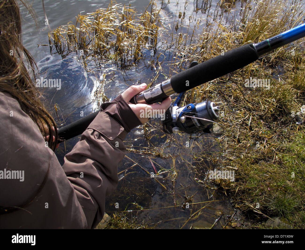 Jeune fille casting canne à pêche à côté canal Banque D'Images