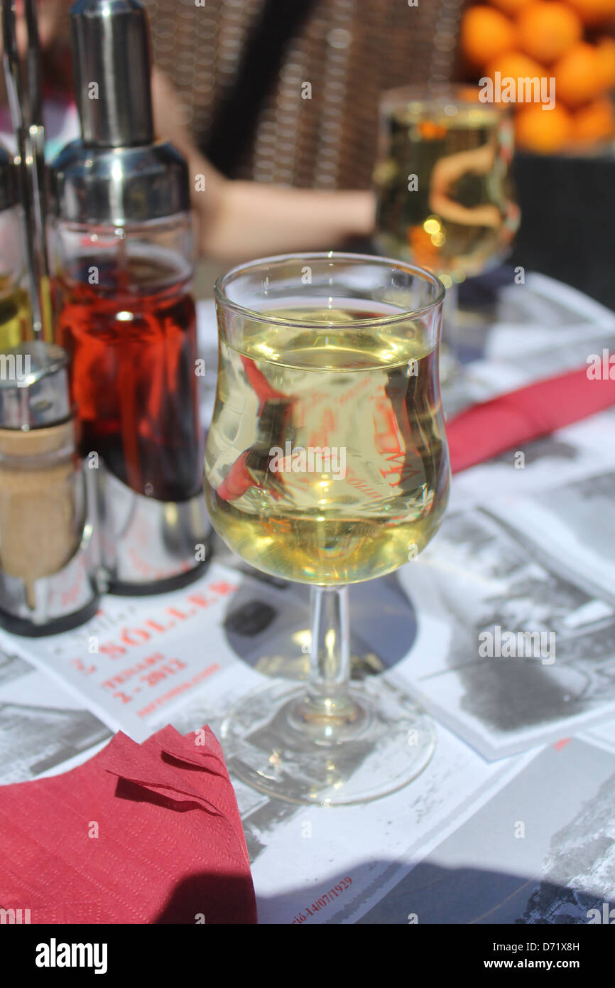 Verre de vin blanc dans le soleil sur la table d'un café espagnol Banque D'Images