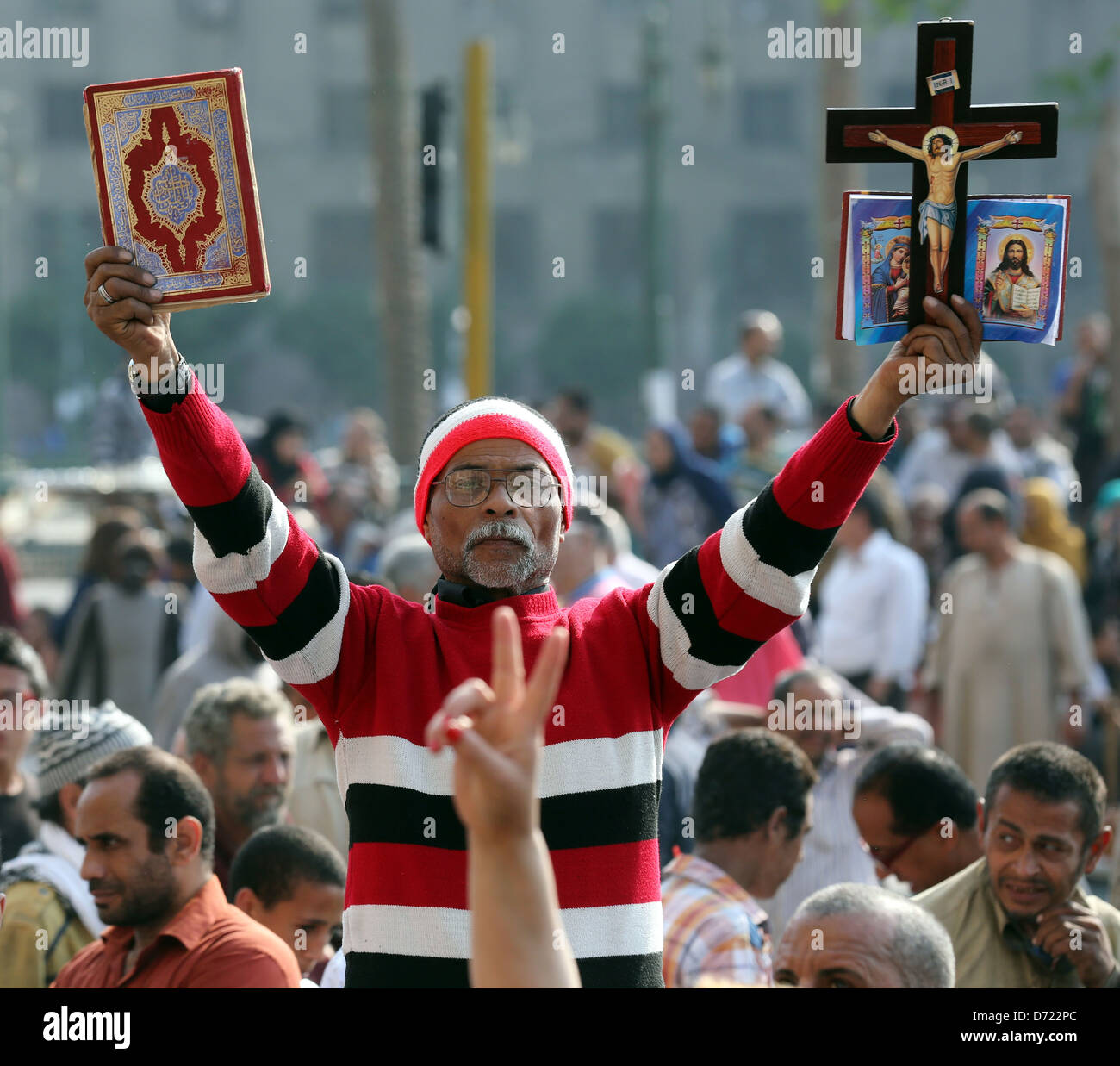 Un égyptien détient le saint Coran et la bible chrétienne avec croix en bois au cours d'un grand rassemblement sur la place Tahrir, Le Caire, Egypte Banque D'Images