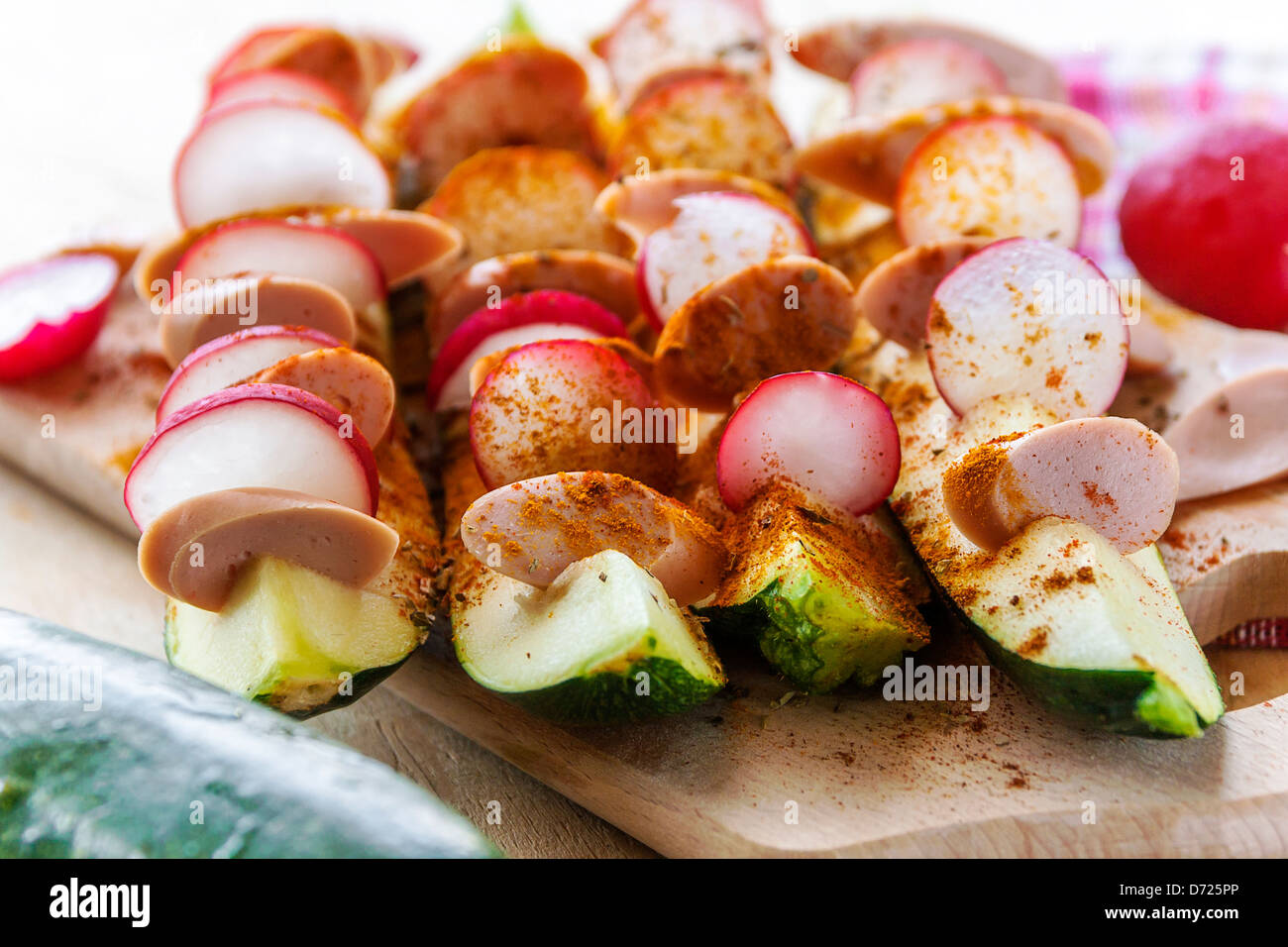 Courgettes grillées farcies avec les radis et les saucisses sur fond de bois Banque D'Images