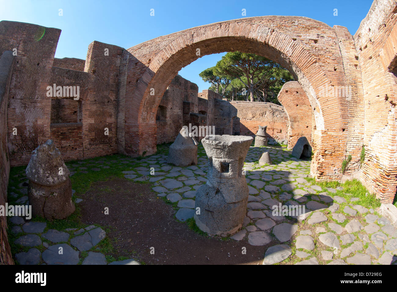 Une boulangerie romaine à Ostia Antica, sculpté avec des meules de pierre ponce pour broyer le maïs Banque D'Images