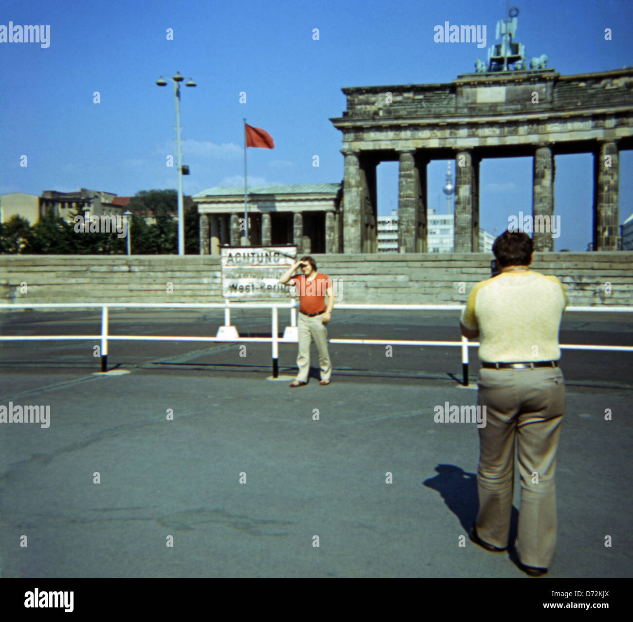 Berlin, Allemagne, l'homme photographié son ami en face du mur de Berlin et de la porte de Brandebourg Banque D'Images