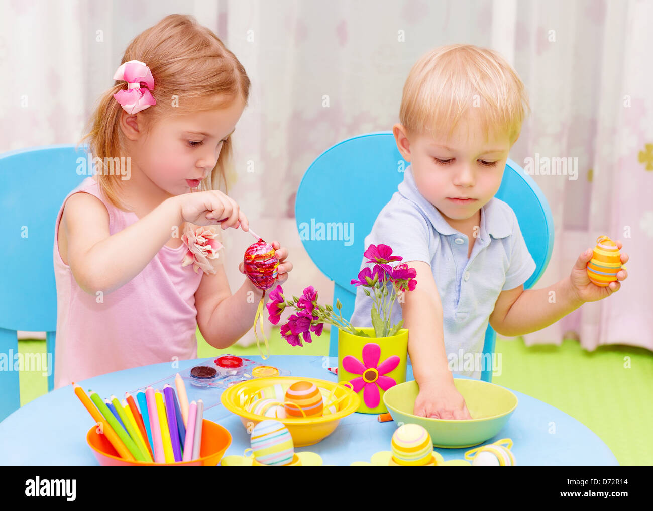 Deux adorables enfants peindre des oeufs de Pâques dans le jardin d'enfants, cours de dessin, de décorations colorées, art traditionnel Eastertime Banque D'Images