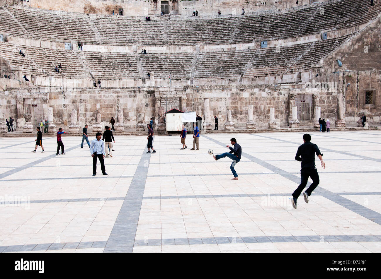La Jordanie, Amman. Les jeunes hommes jouent au football à côté de l'amphithéâtre romain Banque D'Images