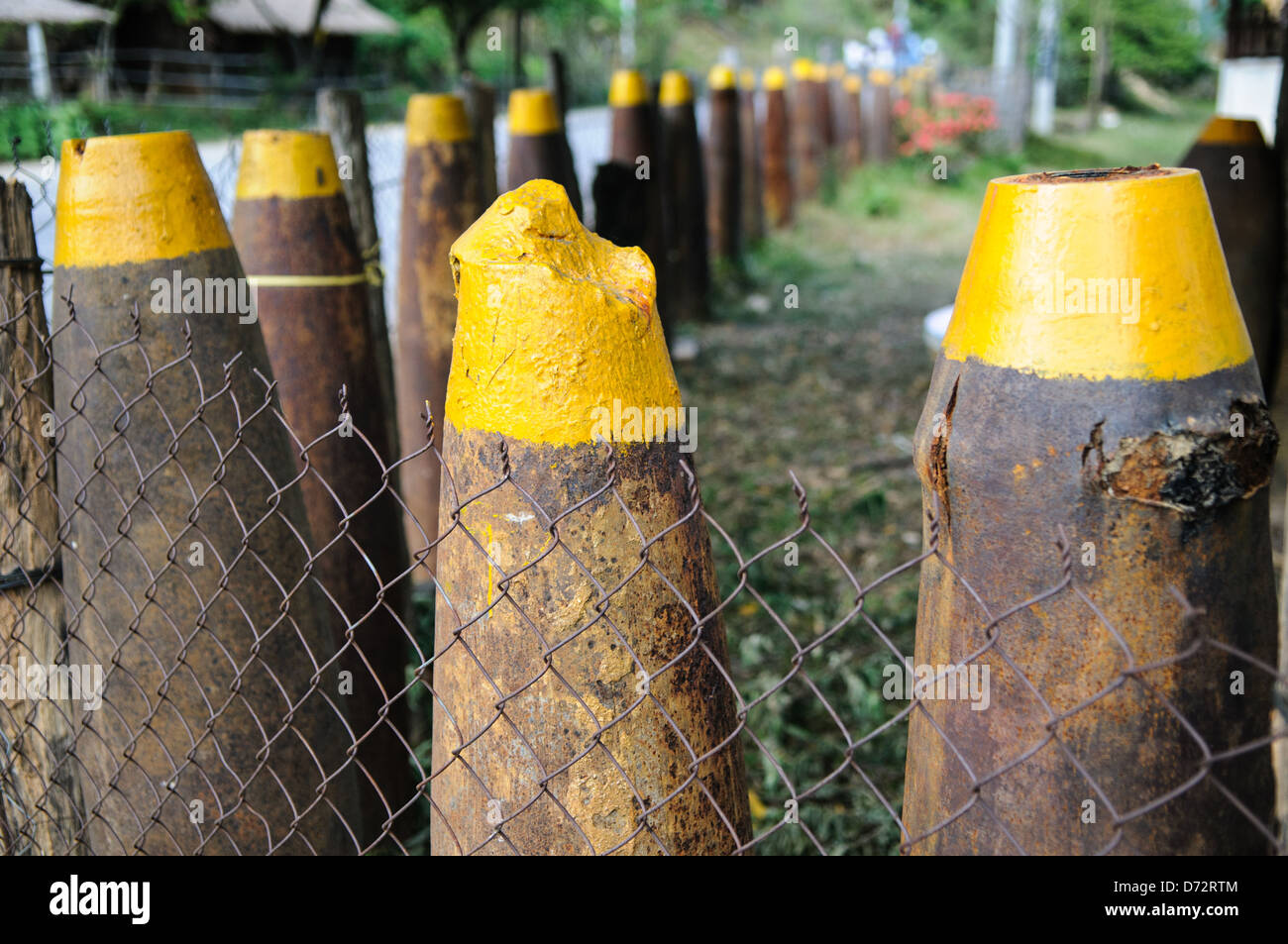 PROVINCE DE XIENG KHOUANG, Laos — Une barrière de munitions fabriquée à partir de munitions non explosées (UXO) entoure un champ dans la région des Plaines de Jarres. Ce rappel poignant de la guerre secrète des années 1960 et 1970 met en évidence l’impact continu du conflit sur le paysage local. La plaine des Jarres est à la fois un site archéologique et historique, reflétant l'histoire complexe du Laos. Banque D'Images