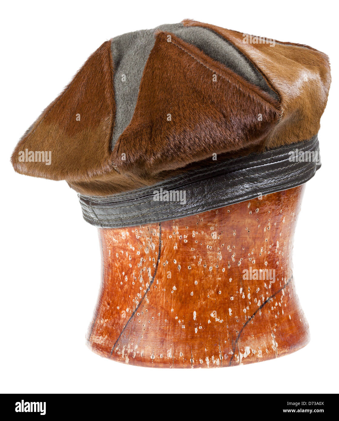 Fourrure brun femme beret hat sur un bloc en bois isolé sur fond blanc Banque D'Images