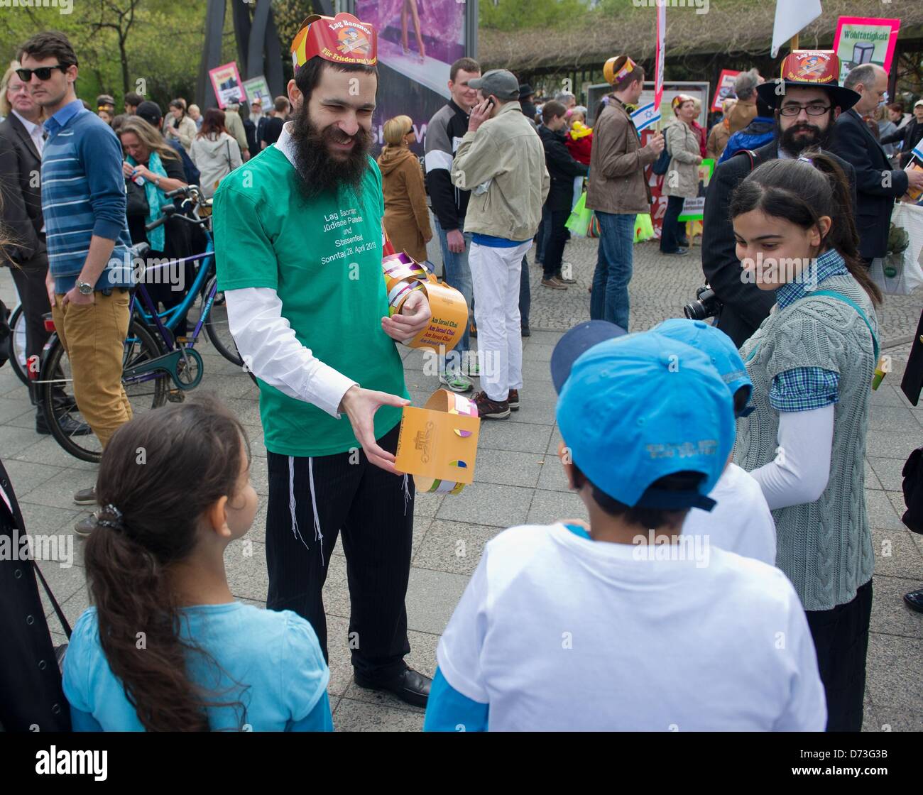 Un participant de la "parade de Lag Baomer' hands out paper crowns à Berlin, Allemagne, 28 avril 2013. La fête juive est célébré à appeler pour plus de respect de l'autre. Photo : TIM BRAKEMEIER Banque D'Images