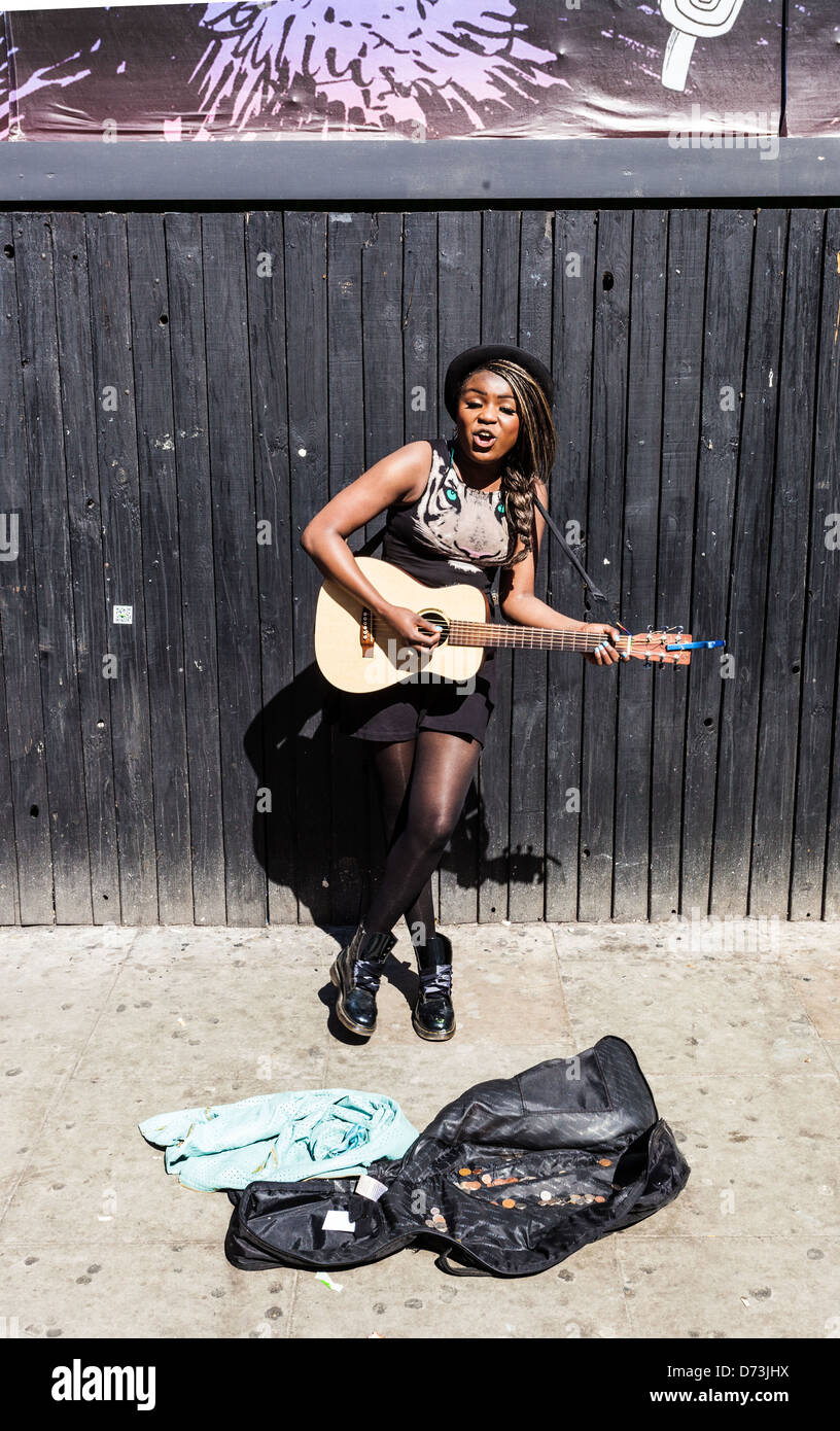 Portrait d'un quartier branché, jeune, femme noire à jouer de la guitare et chant musicien ambulant, Camden, London, England, UK Banque D'Images