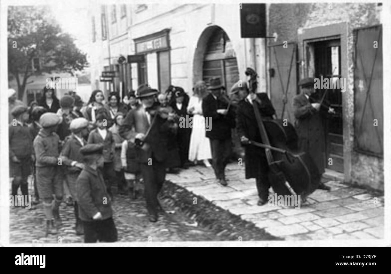 Cette image montre une mariée juive non identifiée conduite à la synagogue par sa famille et des musiciens avant son mariage. Le voile traditionnel et la célébration font partie des coutumes du mariage juif. Banque D'Images