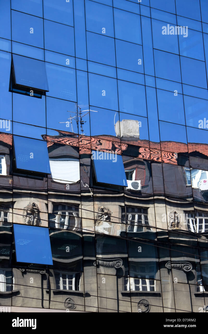 La réflexion d'un bâtiment ancien à la façade moderne en verre Banque D'Images