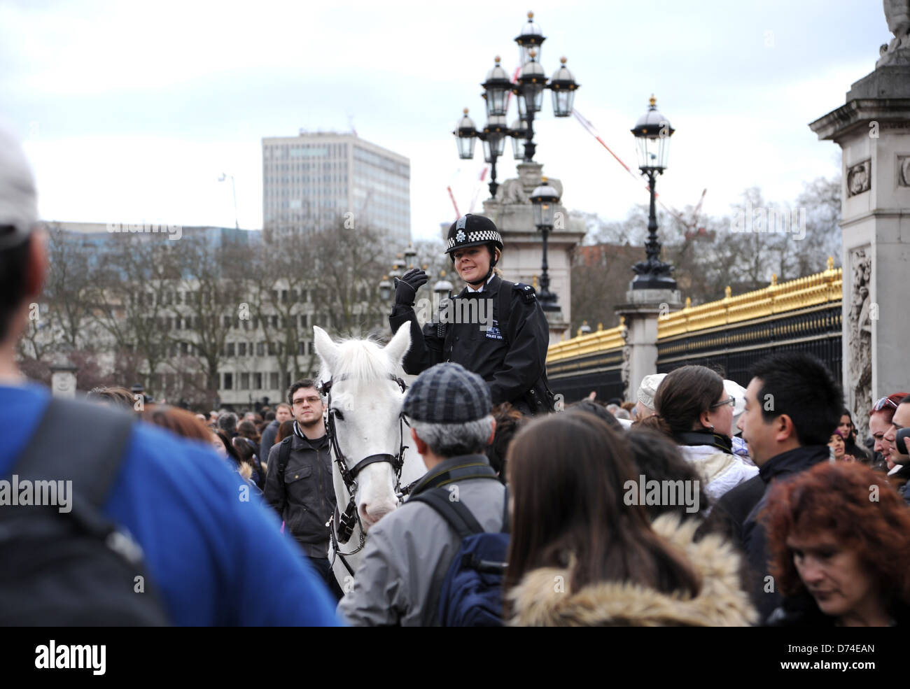 Agent de police féminin sur l'aide au contrôle de la foule lors de la relève de la garde au Palais de Buckingham à Londres, Royaume-Uni Banque D'Images