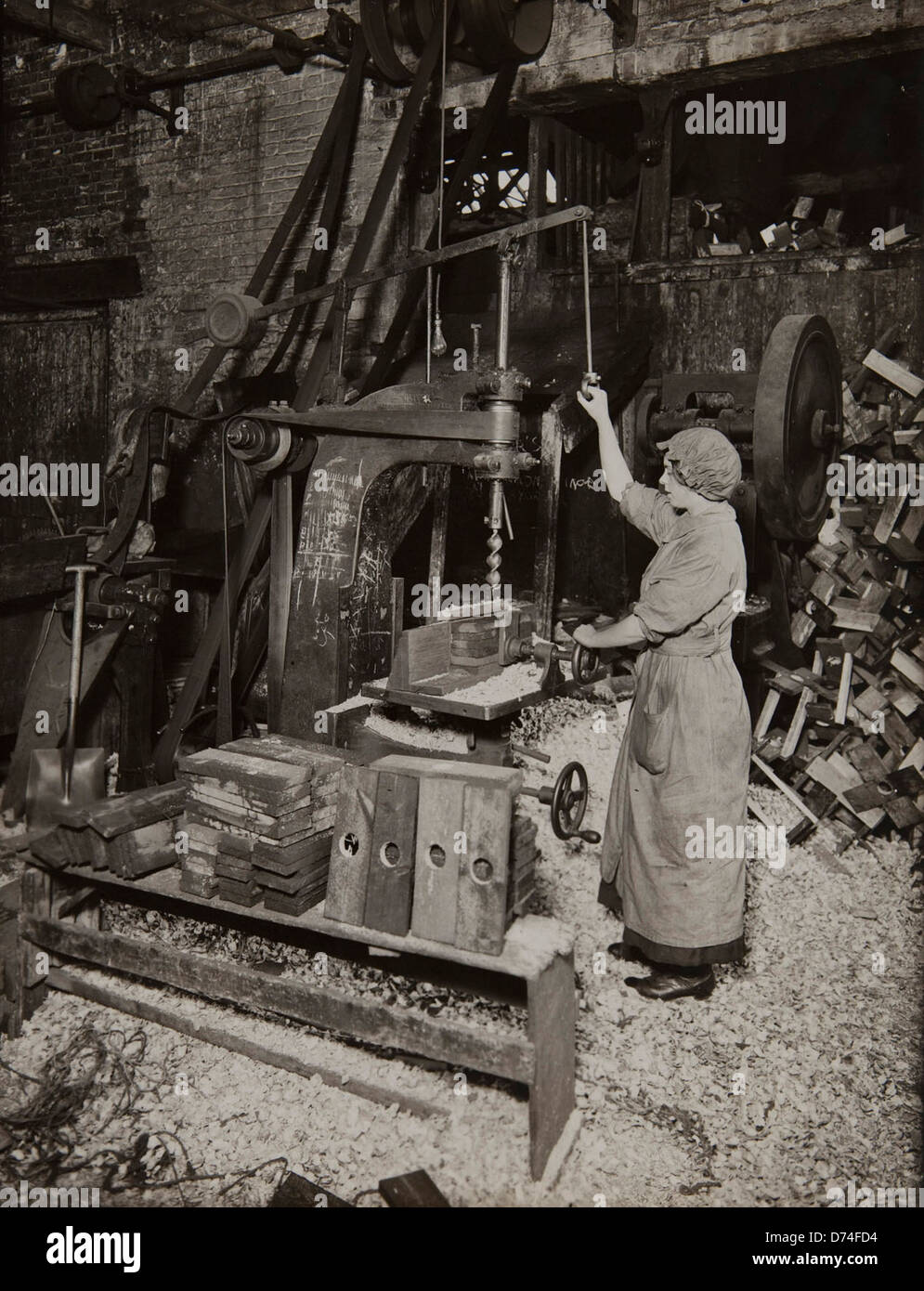 Machine de forage d'exploitation femme ; bobines en bois pour le bobinage du fil de fer barbelé Banque D'Images