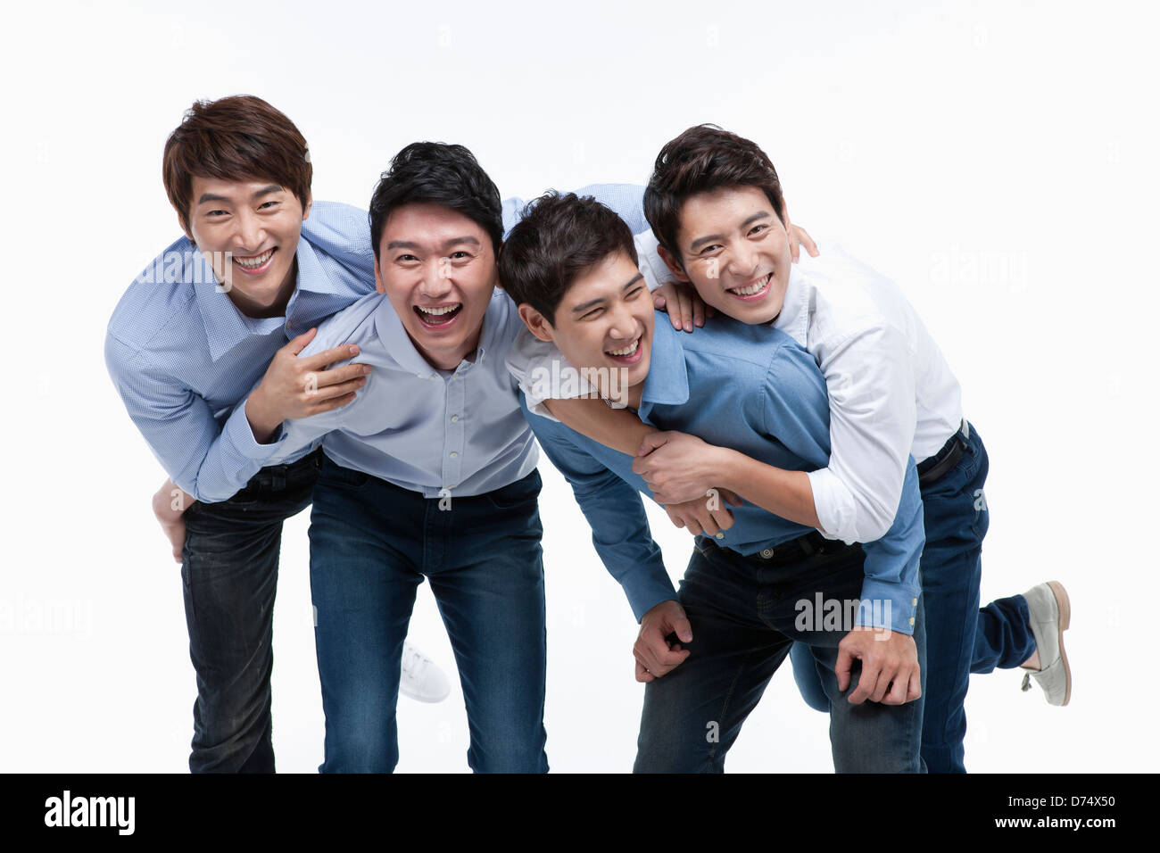 Quatre hommes avec chemises et jeans posing at camera Banque D'Images