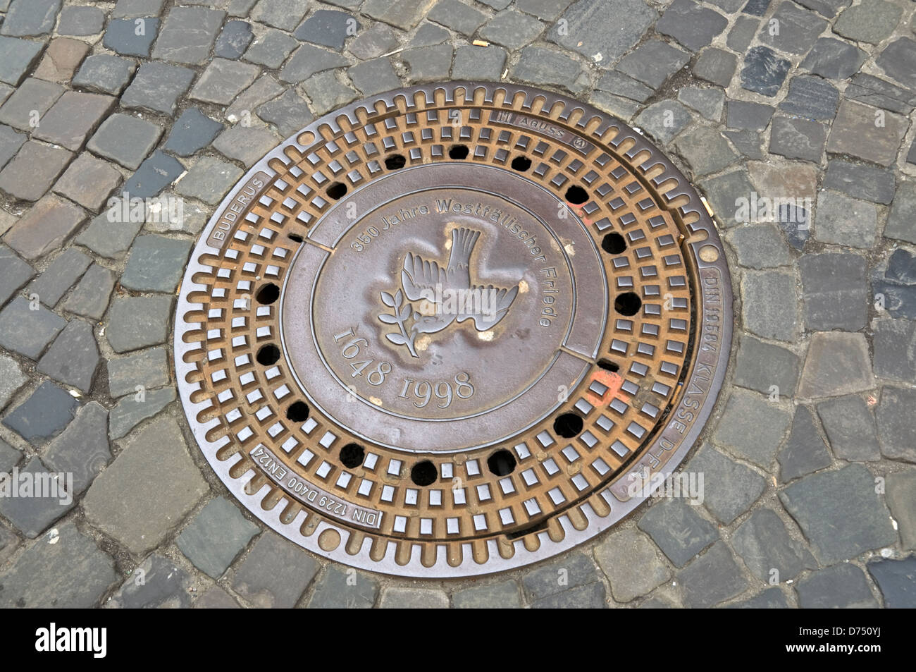 Le couvercle de trou d'homme à Muenster, en Allemagne, en commémoration du 250e anniversaire de la signature du traité de paix de Westphalie. Banque D'Images