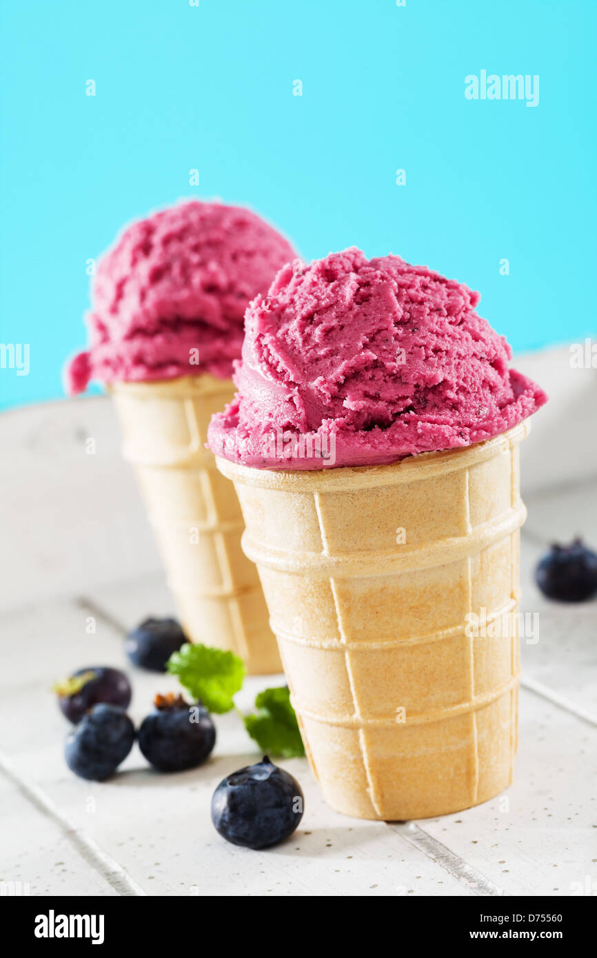 Deux glaces gaufres aux bleuets sur bois blanc avec fond bleu Banque D'Images